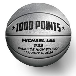 May include: A silver basketball with black text that reads "1000 POINTS" with stars on either side. Below the text is "MICHAEL LEE #23 PARKSIDE HIGH SCHOOL JANUARY 11, 2026". The ball has black lines and a textured surface.