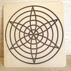 Peut inclure: Une planche carrée en bois brun clair avec un motif géométrique brun foncé. Le motif présente des cercles concentriques, une étoile centrale et des lignes entrecroisées formant un motif en forme d'étoile. La planche a des coins arrondis.