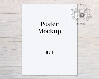 May include: A white poster mockup with the text "Poster Mockup" and "11x14" printed on it. The poster is sitting on a white wooden surface.