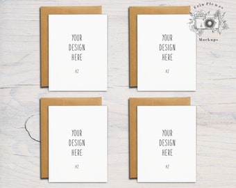 Puede incluir: Cuatro tarjetas blancas de tamaño A2 con sobres marrones. Cada tarjeta tiene el texto "YOUR DESIGN HERE" y "A2" impreso en ella.