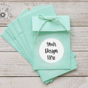 May include: A stack of light blue envelopes tied with twine and a white circle sticker that says "Your Design Here".