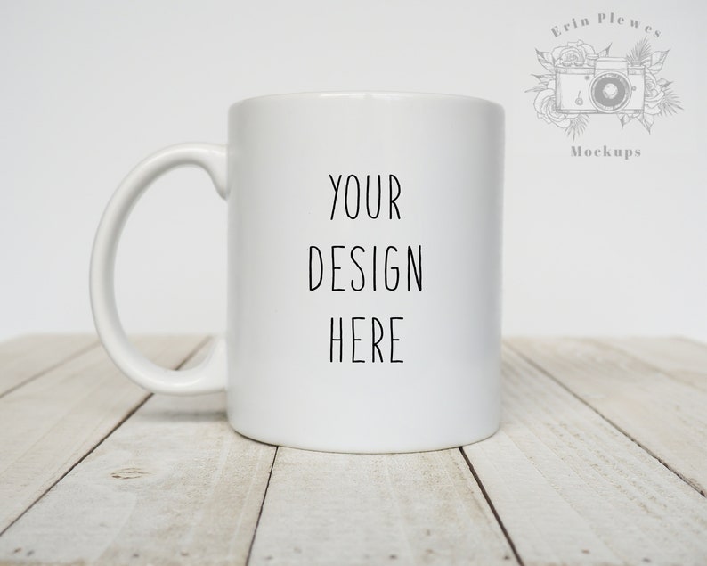 May include: White ceramic mug with a black handle. The mug has the text "YOUR DESIGN HERE" printed on the front.