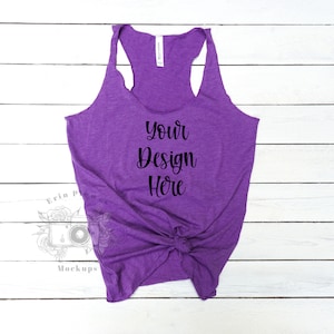 Può includere: Canotta senza maniche viola con un nodo sul davanti. La canotta è realizzata in un tessuto morbido e confortevole e ha una vestibilità rilassata. Il testo "Your Design Here" è stampato sul davanti della canotta.