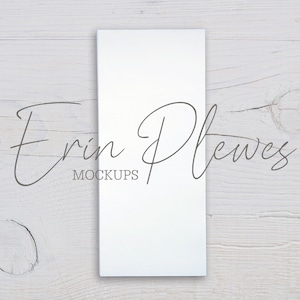 May include: A white rectangular card mockup on a white wood background. The card is blank and ready for your design. The text "Erin Plewes Mockups" is visible in the lower left corner of the image.
