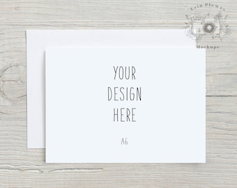 May include: A white card with the text "YOUR DESIGN HERE" and "A6" printed on it. The card is lying on a light wood surface.