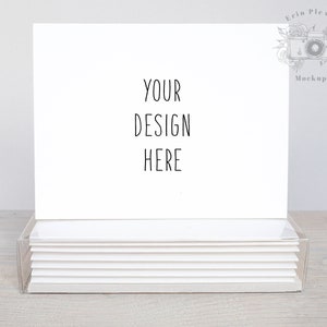 May include: A stack of blank white note cards in a clear plastic box. The top card has the text "YOUR DESIGN HERE" written on it.