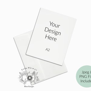 May include: A white A2 size paper mockup with the text "Your Design Here" on it. The paper is folded in half and is sitting on a white surface. The text "Jpeg & PNG Files Included" is written in a circle on the right side of the image.