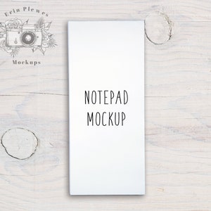 May include: White notepad mockup on a light wood background. The notepad has the text "NOTEPAD MOCKUP" printed on the front.