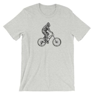 Puede incluir: Una camiseta gris con una ilustraci&oacute;n en blanco y negro de un gorila montando una bicicleta de monta&ntilde;a.