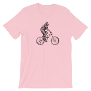 Puede incluir: Una camiseta rosa con una ilustraci&oacute;n en blanco y negro de un gorila montando una bicicleta de monta&ntilde;a.
