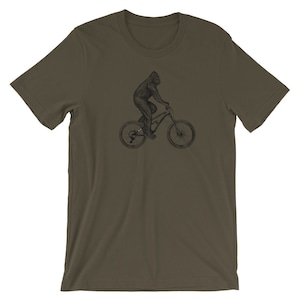 Puede incluir: Una camiseta verde oscuro con una ilustraci&oacute;n en blanco y negro de un gorila montando una bicicleta de monta&ntilde;a.