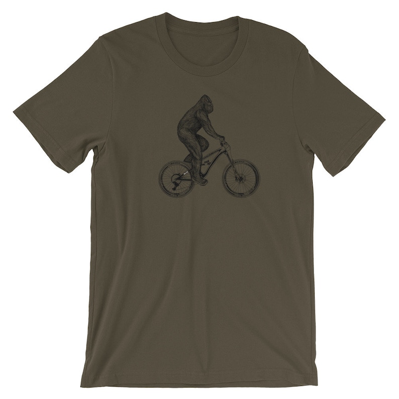 Puede incluir: Una camiseta verde oscuro con una ilustraci&oacute;n en blanco y negro de un gorila montando una bicicleta de monta&ntilde;a.