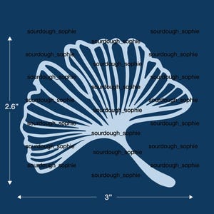 May include: A light blue ginkgo leaf stencil design on a dark blue background. The design features a fan-shaped leaf with radiating veins. A vertical measurement line indicates 2.6 inches and a horizontal line indicates 3 inches in length.