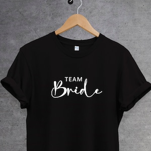 Op de afbeelding: Zwart T-shirt met witte tekst "Team Bride".
