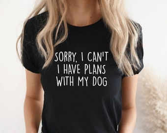 May include: A black t-shirt with the text "Sorry, I can't I have plans with my dog" printed in white.