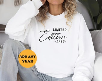 May include: White sweatshirt with the text "LIMITED Edition -1985- " in black script font. The text is centered on the sweatshirt.