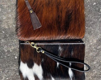 Driekleurige clutch van koeienleer met polsbandje, bruine en witte portemonnee van koeienleer
