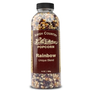 May include: A clear plastic bottle filled with a rainbow blend of popcorn kernels. The label reads "Amish Country Popcorn Rainbow Unique Blend." The bottle is topped with a black cap and contains 14 oz (396g) of popcorn.