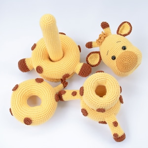 May include: A set of crocheted giraffe toys, including a ring, a head, and a body with a tail. The toys are made of yellow yarn with brown accents.