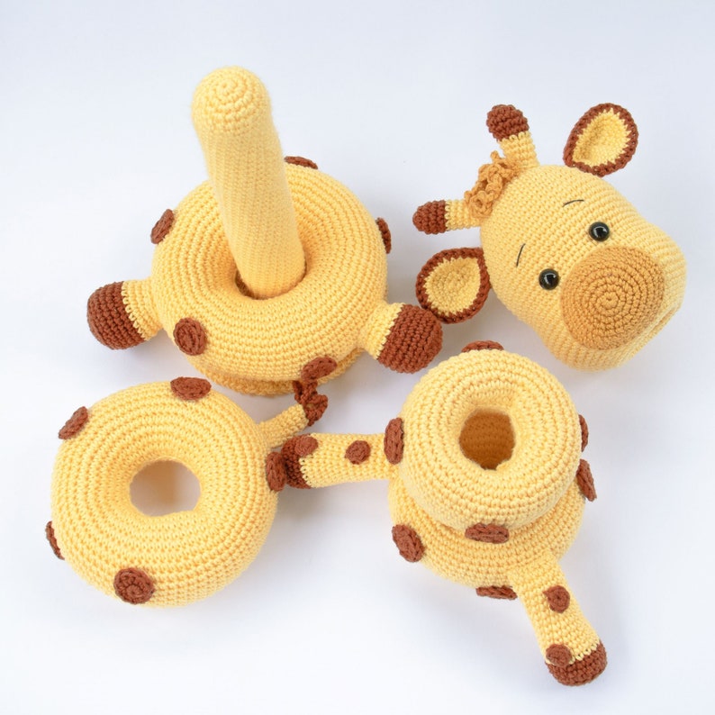 May include: A set of crocheted giraffe toys, including a ring, a head, and a body with a tail. The toys are made of yellow yarn with brown accents.