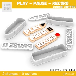 May include: A collection of white plastic cookie cutters and stamps with the words "PLAY," "PAUSE," and "RECORD." The set includes three stamps and three cutters. The text "3 inches" is also visible.