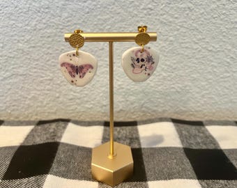 不気味なハロウィーンのダングルイヤリング。黒とピンクの頭蓋骨と蝶のイヤリング