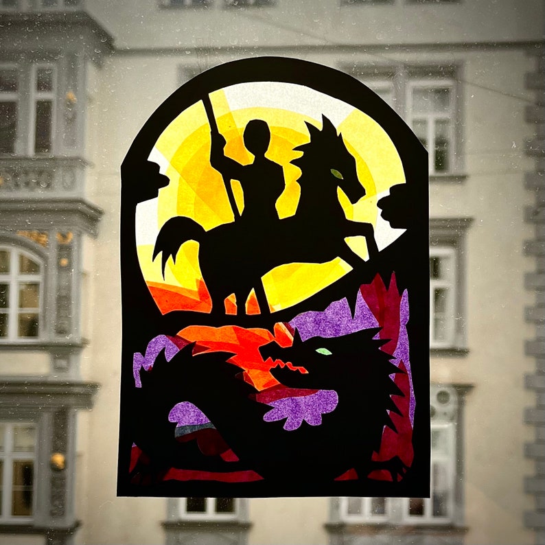 May include: A stained glass window design featuring a knight riding a horse, with a dragon in the foreground. The design is made of colorful paper and has a yellow, orange, purple, and blue color scheme.