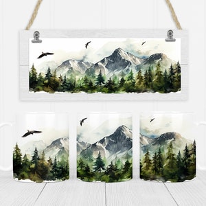 May include: Three white mugs featuring a watercolour design of a mountain range with green trees and a misty sky. The design is centred on the mug and wraps around the sides.