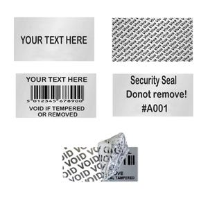 Op de afbeelding: Een verzameling rechthoekige veiligheidslabels met zwarte tekst op een zilveren achtergrond. Kenmerken zijn de teksten YOUR TEXT HERE, Security Seal Donot remove! #A001, een streepjescode en de waarschuwing VOID IF TEMPERED OR REMOVED. Sommige labels tonen een herhalend Viva-patroon of een VOID-effect.