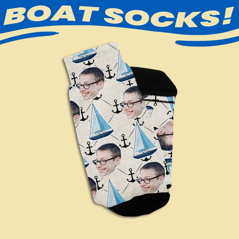 May include: A pair of white socks with a black anchor and sailboat pattern. The socks feature a repeated image of a person's face.