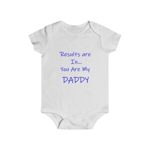 May include: White baby onesie with blue text that reads "Results are In... You Are My Daddy".