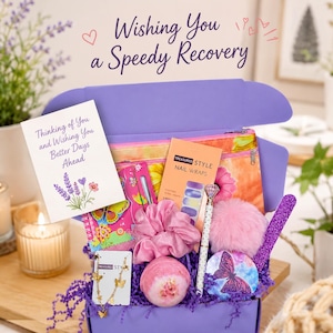 May include: A purple gift box filled with self-care items including a card that reads Wishing You a Speedy Recovery, a floral pouch, nail wraps, a pink scrunchie, a bath bomb, a butterfly necklace, a pen with a diamond topper, and a glittery file.