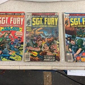 May include: Three vintage Sgt. Fury comic books. The covers feature action-packed illustrations of soldiers in combat, with titles like "Blazing Battle Action" and "To the Bastions of Bavaria." The comics are from Marvel Comics Group.