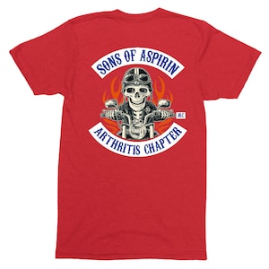 May include: Red t-shirt with a white patch that says "Sons of Aspirin Arthritis Chapter MC". The patch features a skeleton riding a motorcycle with flames behind it.