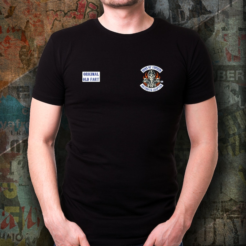 May include: Black t-shirt with a white graphic on the front that says "Original Old Fart" and a blue and white graphic on the right side that says "Sons of Aspirin, Asheville Chapter".