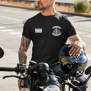 May include: A man wearing a black t-shirt with the text "Original Old Fart" and a patch that says "Sons of Aspirin Arthritis Chapter" is sitting on a black motorcycle.