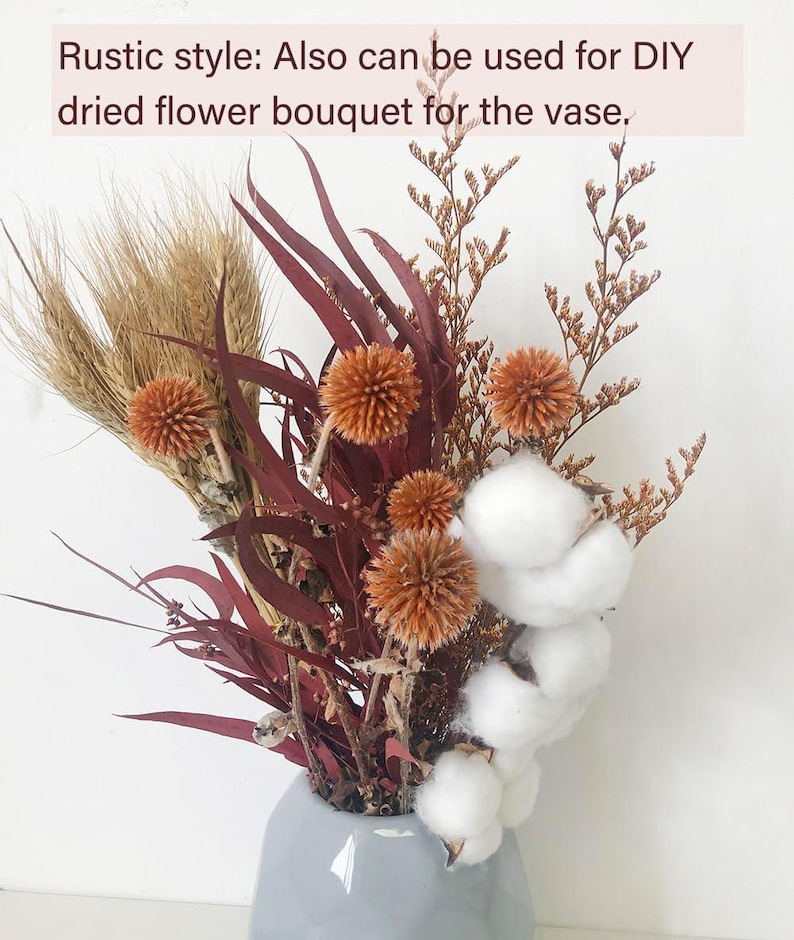 May include: A rustic-style dried flower bouquet in a grey vase. The bouquet includes dried wheat, cotton bolls, and burgundy eucalyptus leaves.