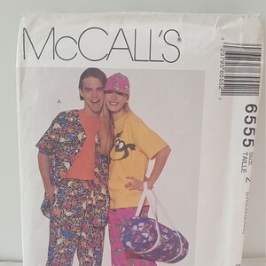 May include: McCall's sewing pattern envelope featuring a man and woman wearing colourful clothing. The pattern is for size 7 and includes a t-shirt for stretch knits only. The envelope has the text "Calhoun Cotton Prints" on the bottom.