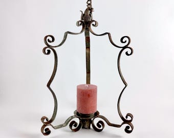 Castiçal de ferro forjado vintage para pendurar, lanterna rústica de fazenda com corrente, detalhes em volutas forjadas à mão, decoração com pátina envelhecida.