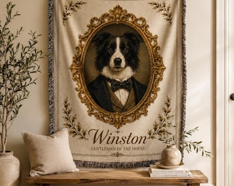 May include: A woven tapestry blanket featuring a portrait of a black and white dog wearing a suit and bowtie inside an ornate gold frame. The text Winston and GENTLEMAN OF THE HOUSE is printed below the portrait on the cream-colored fabric.