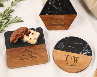 May include: Three personalized coasters with a black marble and wood design. One is hexagonal, one square, and one round. The square coaster has a mountain graphic and the names "Gideon & Althea". The hexagonal coaster has the names "Francis & Nicole" and "Est. 2023". The round coaster has the initials "T | W" and "12.12.2022".