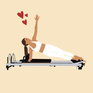 May include: A woman wearing a white sports bra and trousers is performing a side plank on a reformer pilates machine. Her right arm is raised in the air and she is looking upwards. Three red hearts are floating above her head.