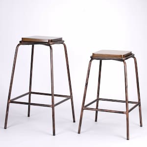 May include: Two metal bar stools with wooden seats. The stools are copper in colour and have a simple, industrial design.