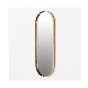 Op de afbeelding: Een ovale spiegel met een gouden frame. De spiegel is lang en smal, met afgeronde uiteinden. Het frame heeft een gladde, metallic afwerking. De spiegel staat tegen een effen witte achtergrond.