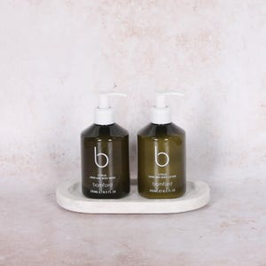 May include: Two dark green pump bottles of hand and body wash and lotion, labeled "Citrus" and "bamford", sit on a white oval tray. Each bottle contains 8.5 fl oz of product. The bottles have white pumps and a stylized "b" logo.