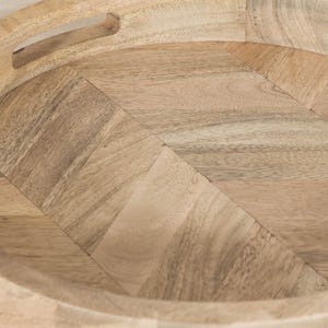 May include: A round wooden tray with a herringbone pattern. The tray has a natural wood finish and a raised edge.