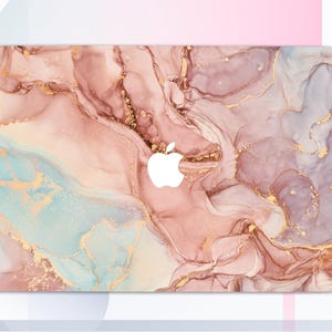 Può includere: Una skin per laptop con un design a marmi rosa, blu e oro. La skin ha un logo Apple bianco al centro.