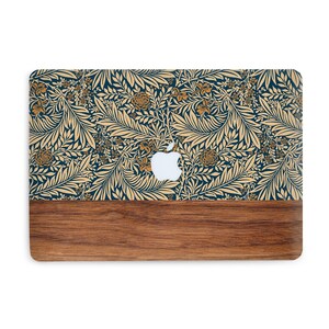 May include: A laptop computer with a wood-grain bottom and a blue and gold floral pattern on the top. The Apple logo is visible on the top of the laptop.