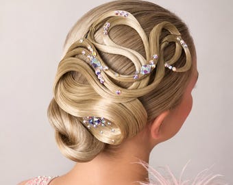 May include: A complex blonde hairstyle featuring intricate loops and swirls of hair secured in an updo. The style is embellished with numerous small, iridescent, multi-faceted crystals and larger, clear, square-cut rhinestones throughout the hair.