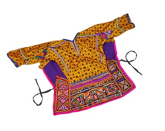 May include: A yellow, purple, and pink embroidered top with colorful geometric patterns and black ties. The top is made of a thin fabric and has a loose fit.